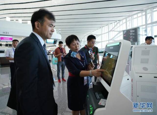 中国东方航空公司工作人员（前左二）在指导乘客通过“人脸识别”办理值机手续（2019年9月25日摄）。新华社记者鞠焕宗摄