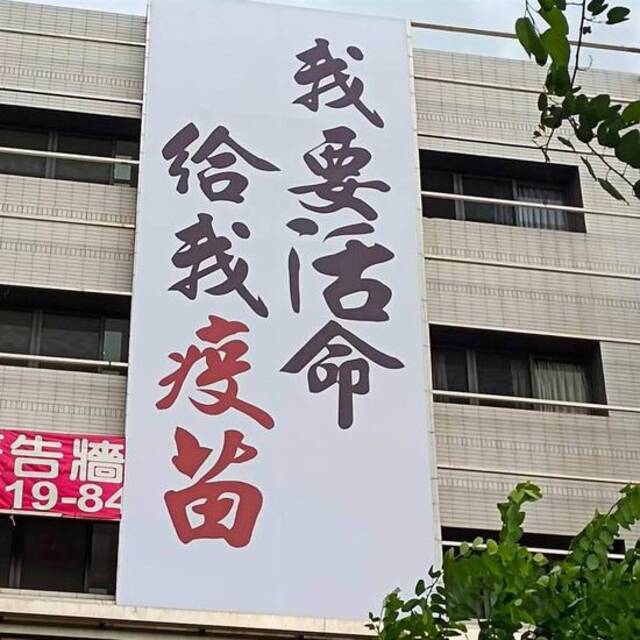 一高楼外悬挂着白布条，上面写有“我要活命给我疫苗”。图自罗智强脸书