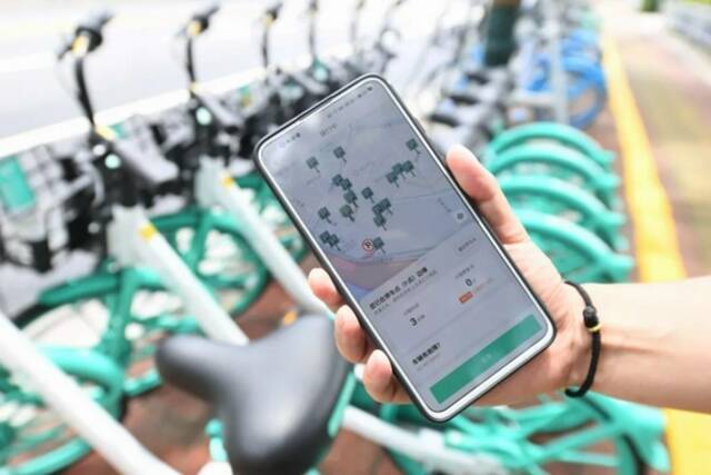 工作人员通过手机App展示福州市台江区一处共享单车指定停放点信息林善传摄