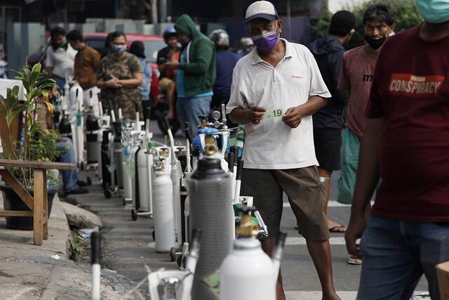 当地时间2021年7月5日，印尼雅加达，市民排队给氧气瓶充氧。人民视觉图
