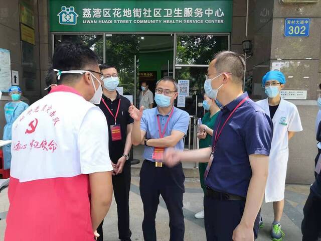 今年6月，吴浩（左三）在广州荔湾区花地街社区卫生服务中心指导疫情防控工作。受访者供图