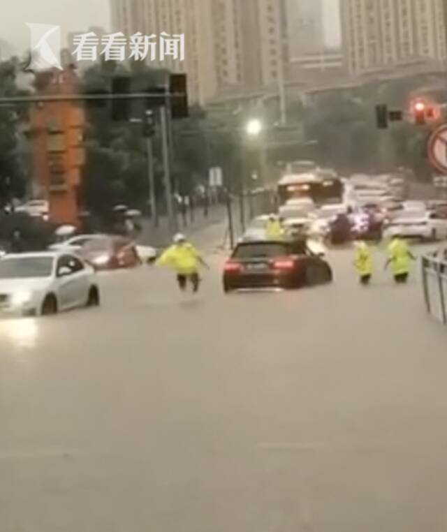 视频｜雨水灌满鞋子 他在积水中奋力跳起去推车