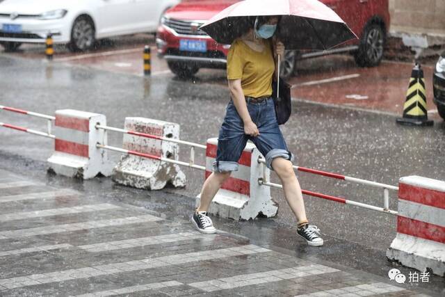 7月12日，蒲黄榆，市民跨过积水区域。摄影/新京报记者王嘉宁