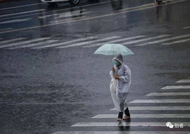 7月12日，门头沟，市民穿雨衣出行。摄影/新京报记者陶冉