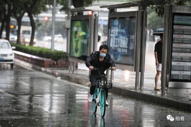 7月12日，蒲黄榆，市民在雨中骑自行车。摄影/新京报记者王嘉宁