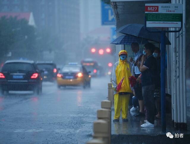 7月12日，门头沟，志愿者在公交车站维持秩序。摄影/新京报记者陶冉