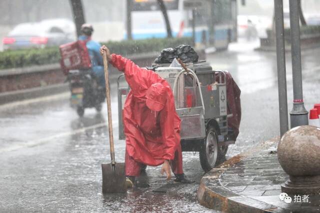 7月12日，蒲黄榆，环卫工人正在清理雨箅子。摄影/新京报记者王嘉宁