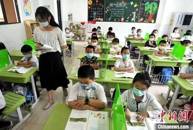 资料图：小学老师给一年级学生上课。中新社记者张斌摄