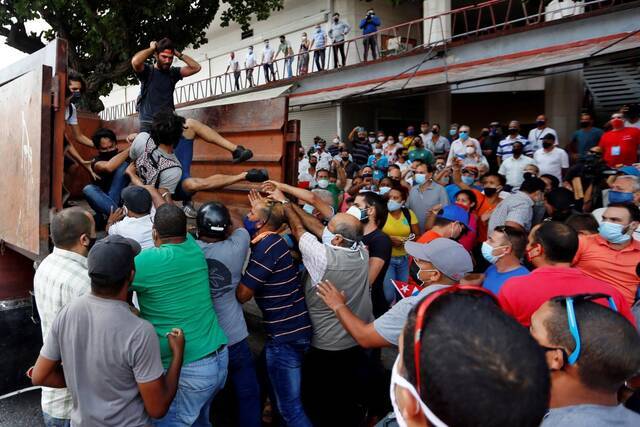 ▲当地时间7月11日，古巴首都哈瓦那，民众将举行游行的反政府抗议者强行推上卡车。图据EPA-EFE