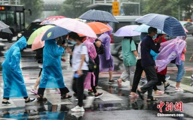 7月12日，北京朝阳区团结湖附近，民众通过路口。中新社记者贾天勇摄