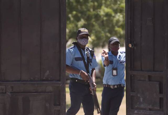 当地时间7月10日，海地太子港，警察守卫在遇袭身亡的海地总统莫伊兹的停尸房附近。/IC photo