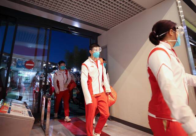  7月17日，中国乒乓球队成员马龙（右二）抵达东京成田机场。新华社记者曹灿摄