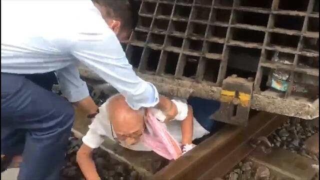 印度一辆火车紧急刹车 人们从车底救出穿越铁轨的老人