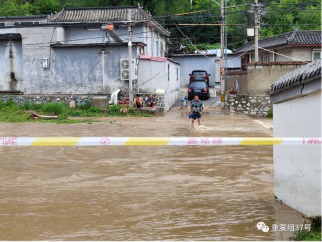 ▲7月18日，受暴雨天气影响，北京门头沟区担礼村进村的漫水桥被淹。村里安排专人在两侧桥头值守，提醒趟水过桥的村民注意安全。新京报记者慕宏举摄