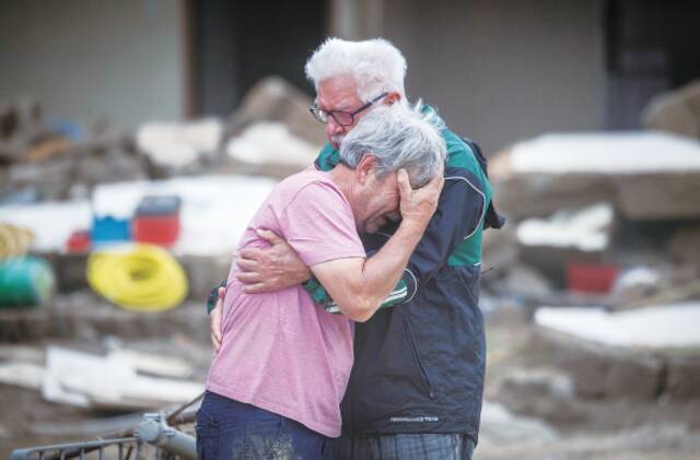 19日，肆虐欧洲西部的洪灾已造成超过200人死亡。图为在受灾严重的德国阿尔特纳尔，面对灾后惨状，一对兄弟相拥哭泣。