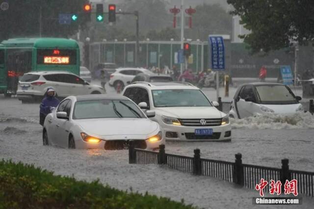 7月20日，河南郑州，车辆经过积水路段。中新社记者李超庆摄