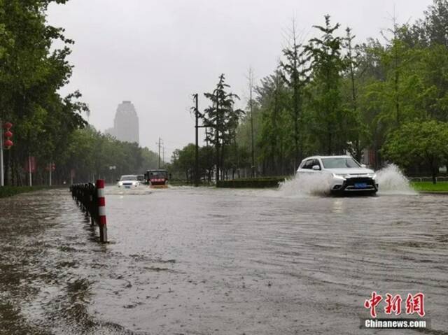 7月20日，河南郑州，车辆从积水路段通过。中新社记者李贵刚摄