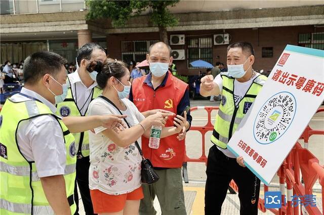 ■6月21日，东莞开展全员核酸检测。图为党员志愿者和义警在引导群众做核酸检测