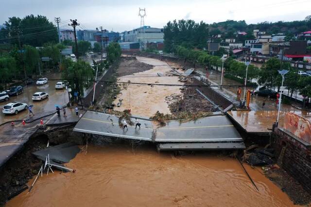 21日，河南巩义市米河镇，遇强降雨后，有房屋冲毁、车辆掀翻，道路成泥潭。图源：东方IC