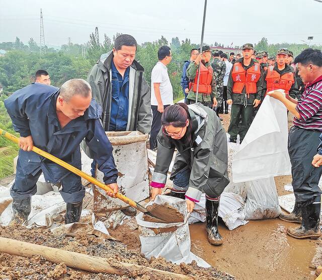 新密市党员干部采取措施，排除积水，恢复供水。（翟银发徐爱远摄）