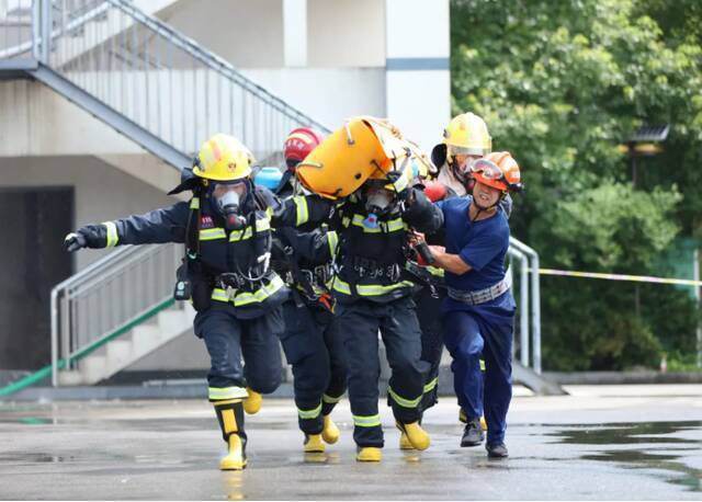 ▲7月21日，在湖南张家界市特勤消防救援站，消防救援人员在进行楼层火灾救人操训练。当日，该市消防救援支队举行夏季岗位大练兵活动，锤炼消防救援人员在高温酷暑中的业务技能，提升队伍综合应急救援实战能力。图片来源：新华社