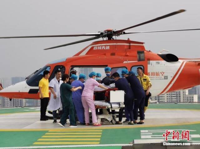  7月22日，受灾严重的郑州市阜外华中心血管病医院通过直升机、冲锋舟、皮划艇向外转运患者。图为医护人员将一名危重病患婴儿送上直升机进行转移。中新社发王登峰摄