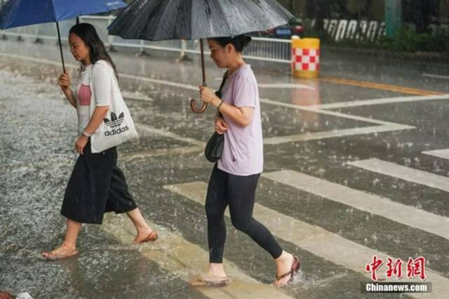 7月22日，受台风“查帕卡”影响，广西南宁市迎来暴雨天气，市民冒雨出行。陈冠言摄