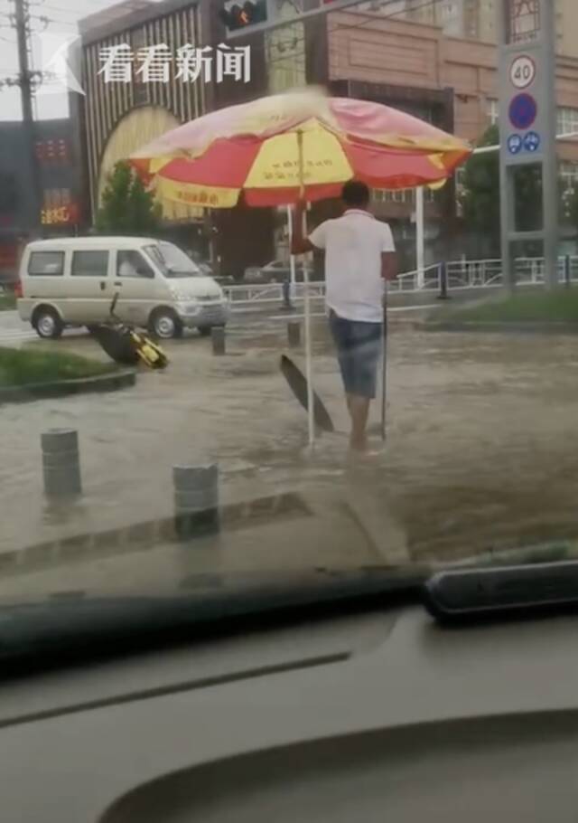 视频｜道路积水小伙冒雨打开窨井，还站一旁默默守护