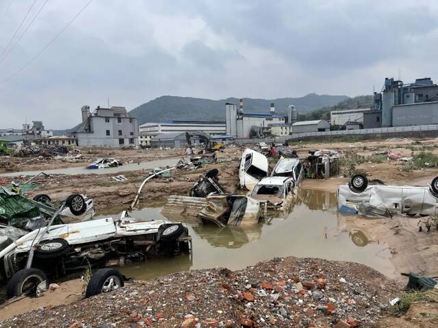 7月22日，在米河镇金阳光汽修店北边低洼处形成的一处小型池塘里一二十辆车叠罗汉般，沉入水里或陷入泥里，水坑边上是刺鼻的汽油味。新京报记者王瑞文摄