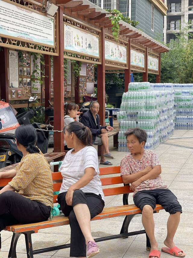 7月23日，村民正坐在路边聊天。新京报记者王瑞文摄