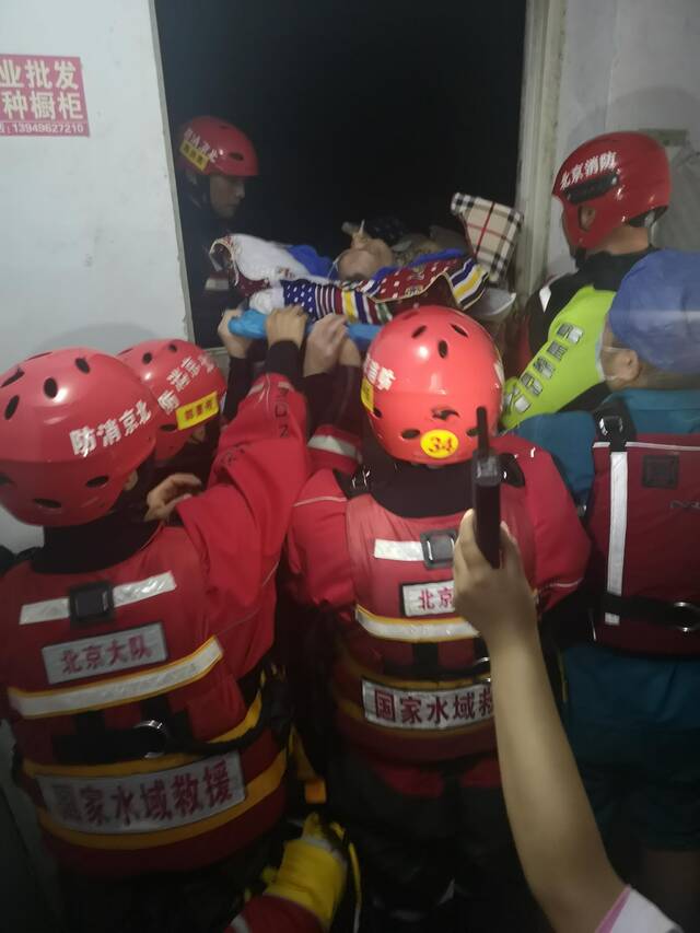 7月24日，救援人员用担架将老人抬出。受访者供图