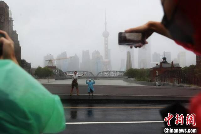 台风“烟花”逼近上海 民众雨中“任性”出游