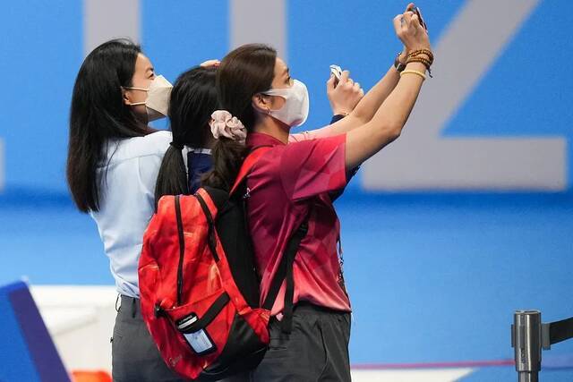 郭晶晶还拿起手机，为两名选手拍照图源：视觉中国