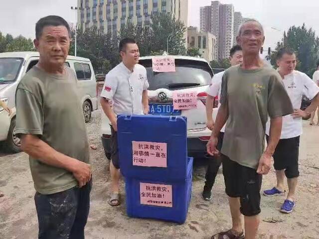 7月21日，郑州湘鄂情餐饮公司员工在给救援人员送餐。受访者供图