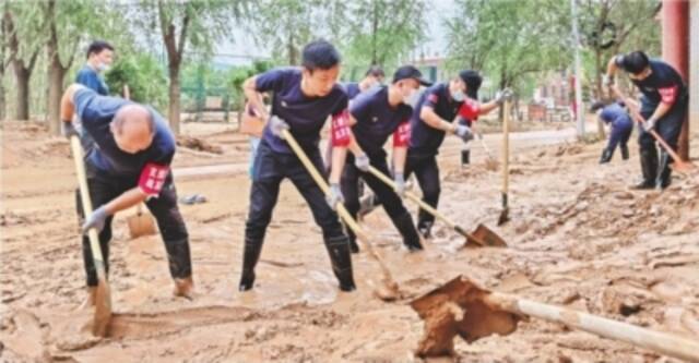 踩着没膝淤泥挥锹清淤恢复交通