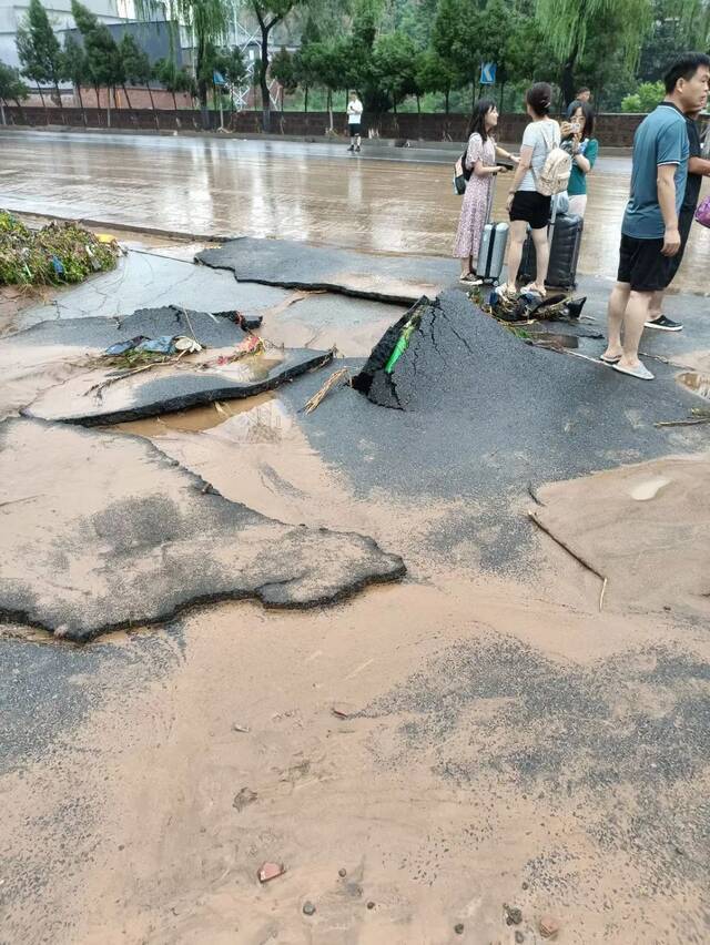 ▲水退下后，路面堆满泥沙，沥青公路像破碎的塑胶跑道一样翻起。（受访者供图）