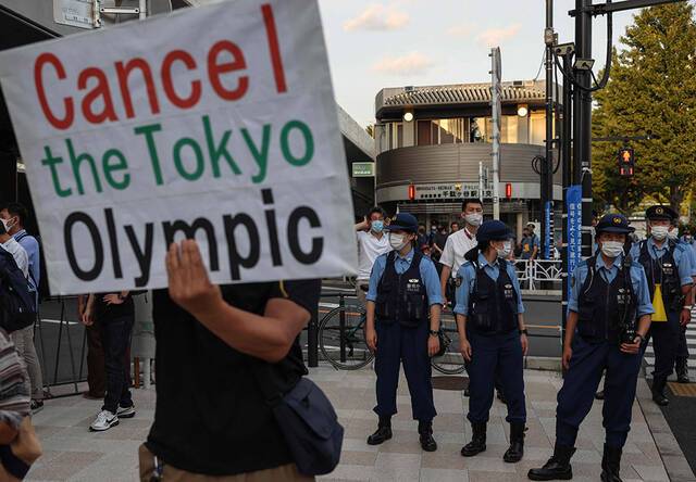 2021年7月23日，日本东京，2020东京奥运会开幕式举行当晚，不少人举着“奥运中止”标语牌和横幅。人民视觉图