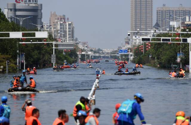 7月27日，在积水严重的卫辉城区，救援人员在搜救被困群众。新华社记者李嘉南摄
