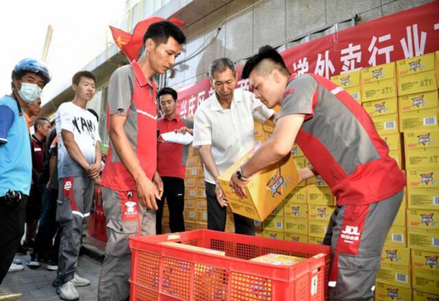 7月21日，银川市兴庆区新华街工会工作人员为快递员、外卖送餐员发放慰问品。新华社记者王鹏摄