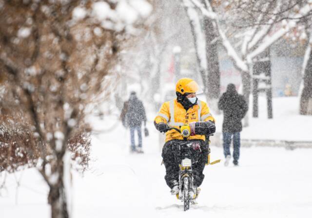 1月23日，在乌鲁木齐市光明路，一名外卖员在送餐路上。新华社记者王菲摄