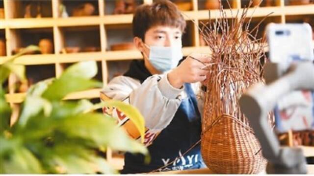 贵州省榕江县大十字社区某科技公司工坊内，一名员工正在进行网上蕨编技能培训。王炳真摄（人民图片）