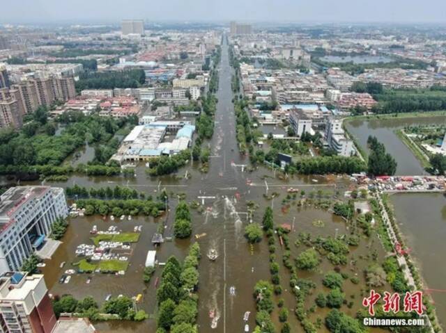 7月26日，河南省卫辉市城区部分路段尚有积水，多支救援力量在当地展开救援工作。中新社记者崔楠摄