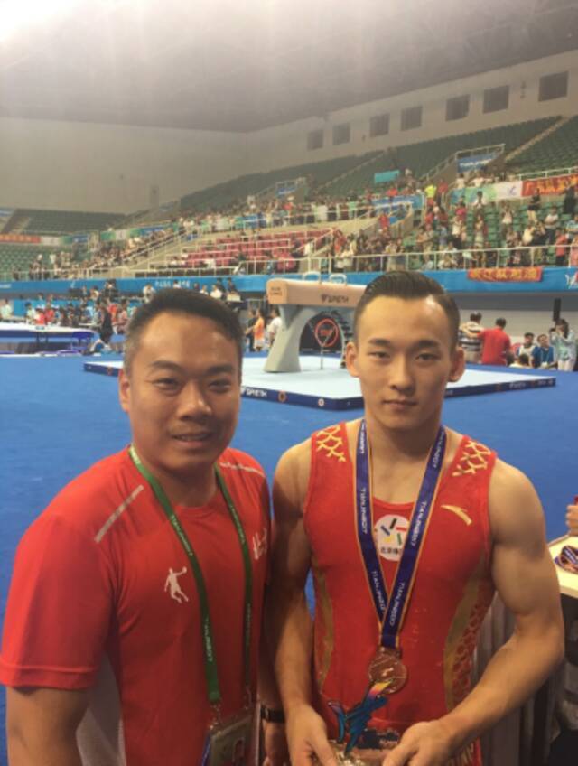 北京体操男队主教练陈刚与弟子肖若腾合影。受访者供图