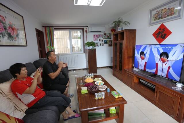 张家齐的父母通过电视直播看女儿比赛。新京报记者郑新洽摄