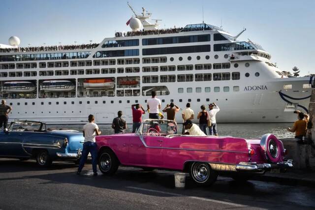 2016年5月2日，在古巴哈瓦那港，人们观看抵达的美国商业邮轮“阿多尼亚”号。这是50多年来首艘商业邮轮从美国启航抵达古巴。新华社/法新
