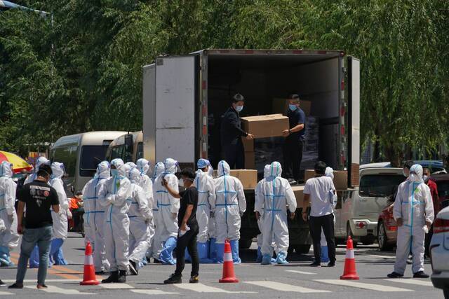 工作人员正从车上搬运物资。本组图片均由新京报记者裴剑飞摄