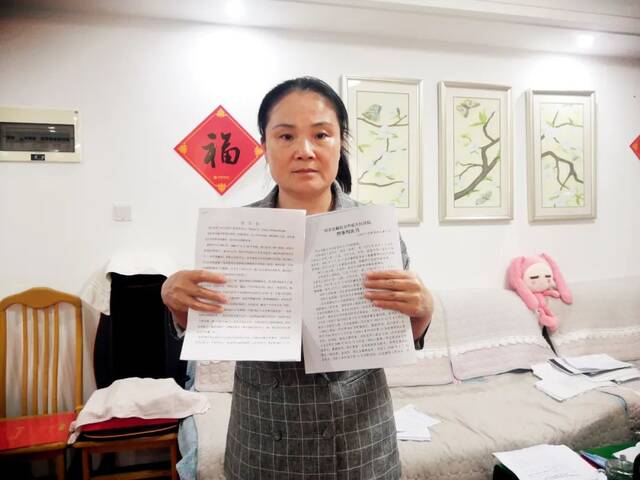  5月19日，原伟东妻子李杰在其天津住所中手持举报信和判决书。摄影/本刊记者周群峰