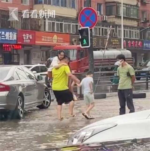 视频｜暴雨积水，爸爸左手扛起妈妈右手牵儿子趟水过街