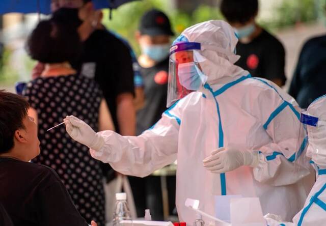 ▲ 7月31日，长沙市天心区赤岭路街道南大桥社区，工作人员对市民进行核酸检测取样。