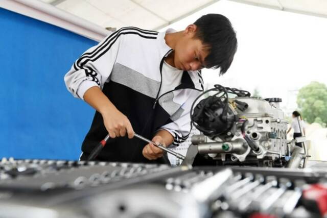 2021年7月，贵州省仁怀市中等职业学校汽车工程部的学生在维修汽车发动机。
